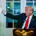 Donald Trump sostiene una maqueta del Arco del Triunfo durante una recepción en la Casa Blanca.