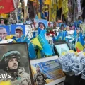 Personas guardan silencio en la plaza Maidan de Kyiv durante el aniversario.