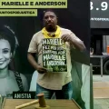Hombre con cartel en apoyo a Marielle Franco afuera del tribunal donde se realizó el juicio.