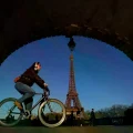 Una mujer en bicicleta cerca de la Torre Eiffel en París.