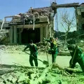 Iraníes pasan junto a edificios bombardeados en Teherán.