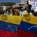 Manifestantes en Caracas portando banderas venezolanas.