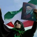 Una mujer iraní muestra una imagen del fallecido ayatolá Ali Khamenei.