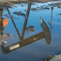 Un pozo se refleja en un charco en el campo petrolífero de San Ardo, California.