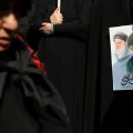 Una mujer muestra una imagen del líder supremo iraní, ayatollah Ali Khamenei.