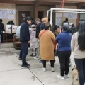 Votantes en fila en un recinto electoral.