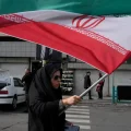 Una mujer marcha con una bandera de Irán en Teherán.
