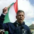 Un partidario de Magyar sostiene una pancarta con su eslogan 'Ahora'.