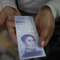 Una mujer muestra un nuevo billete de 500.000 bolívares en un banco de Caracas en marzo de 2021.