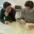 Un estudiante sueco sostiene un libro de texto en un aula.