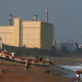 Unos pescadores amarran una barca cerca de la central nuclear Madras Atomic Power Station, en Kalpakkam, India.