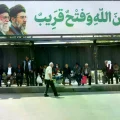 Un cartel con la imagen de los líderes iraníes en una parada de colectivos en Teherán.