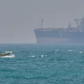 Un barco pasa junto a un petrolero anclado en el estrecho de Ormuz, frente a la costa de la isla de Qeshm, Irán, el 18 de abr