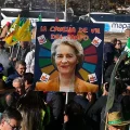 Un cartel que representa a la presidenta de la Comisión como el personaje Cruella de Vil es sostenido por agricultores en Mad