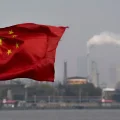 Una bandera china ondea frente a la refinería de Shanghai Gaoqiao en Shanghái.