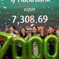 Empleados de Hana Bank celebran que el KOSPI supera los siete mil puntos, en Seúl, 6 de mayo de 2026.