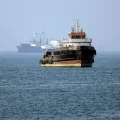 El remolcador Basim, con bandera iraní, navega cerca de un barco anclado en el estrecho de Ormuz, frente a Bandar Abbas, en e