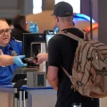 Un empleado de la TSA devuelve el pasaporte a un viajero en Pittsburgh.