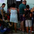 Personas comen después de recibir comida donada por la iglesia griega en el centro de Atenas, Grecia.