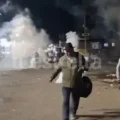 Algunos transeúntes escapan de los gases lacrimógenos.