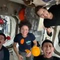 Los astronautas posan con fruta fresca en microgravedad a bordo de la ISS.