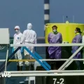 Trabajadores con equipo de protección abordan el MV Hondius en Róterdam.