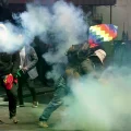 Manifestantes devuelven latas de gas lacrimógeno disparadas por policías durante un enfrentamiento en La Paz.
