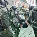 Una periodista es rescatada por la Policía tras ser afectada por gases lacrimógenos.