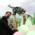 Una pareja de novios iraníes llega en un vehículo militar durante una boda colectiva en Teherán.