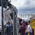 Personas trepan las rejas del perímetro del aeropuerto de El Alto para no perder su vuelo.