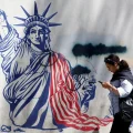 Una iraní camina junto a un mural antiestadounidense cerca de la antigua Embajada de Estados Unidos en Teherán.