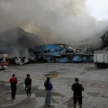 Bomberos y periodistas trabajan en el lugar de un ataque con drones rusos, en Dnipro.