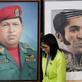 La presidenta interina de Venezuela, Delcy Rodríguez, pasa junto a una imagen del expresidente Hugo Chávez (izquierda) y del