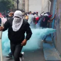 Manifestantes de la CNTE intentan derribar una valla durante una protesta en Ciudad de México.