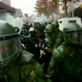 Una manifestante sangra mientras es detenida por la policía antidisturbios durante una protesta en Santiago.