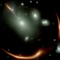 Imagen del JWST de la galaxia distorsionada MRG-M0138 vista a través de un cúmulo de galaxias en primer plano.