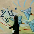 Una mujer iraní pasa junto a un mural antiisraelí en Teherán.