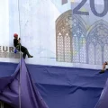 Montañeros descienden en rápel desde la sede del Banco Central Europeo para desplegar réplicas gigantes de los nuevos billetes de euro durante la presentación de la moneda.