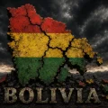 Mapa de Bolivia agrietado y fragmentado, pintado con los colores rojo, amarillo y verde de la bandera nacional, sobre un fondo oscuro y tormentoso que simboliza la crisis, la división y los desafíos que enfrenta el país.